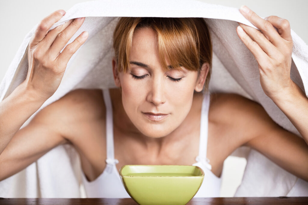An Easy Natural Remedy To Clear a Congested Nose. Woman with congested nose. Woman steam inhalation